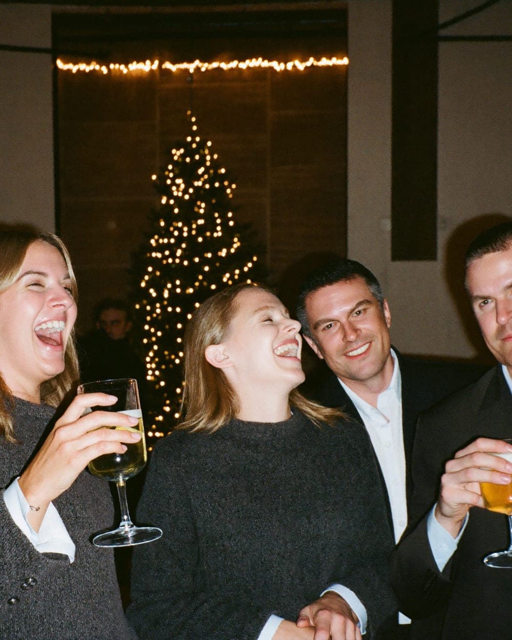 Collega's proosten bij de kerstboom op de kerstborrel