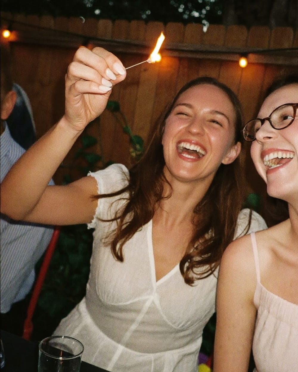 Twee vriendinnen lachen om een sterretje op het tuinfeest