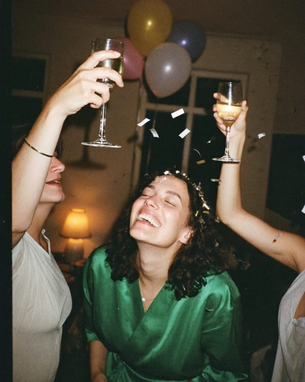 De jarige lacht onder de confetti terwijl haar vrienden proosten