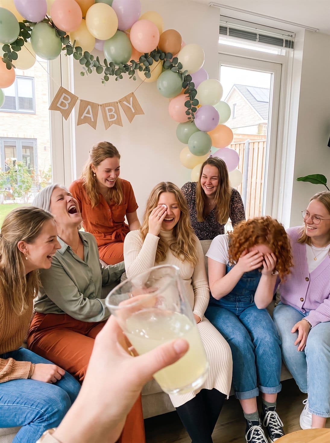 De hele babyshower in een lachbui op de bank