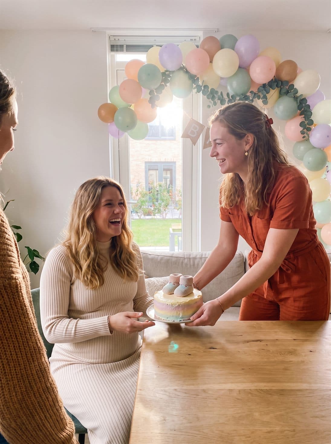 De babyshowertaart met slofjes wordt op tafel gezet