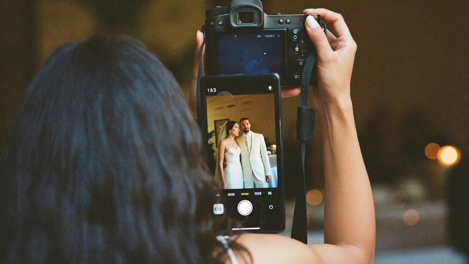 De trouwfotograaf laat een foto van het bruidspaar zien op het schermpje van haar camera